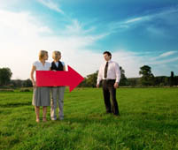 While standing in a feidl, two people are holding a red arrow and pointing it at one man - Peter Barron Stark