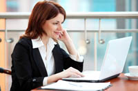 Woman happily looking at lap top - focusing at work - Peter Barron Stark Companies