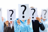 People holding up question signs - peter barron stark