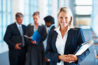 Woman standing in front of a team signifying leadership and happy employees