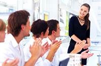 Woman happily speaking in front of colleagues - Peter Barron Stark Companies