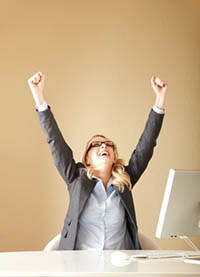Happy employee at her computer - Peter Barron Stark Companies