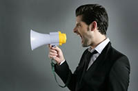 A man yelling into a microphone symbolizing bad leadership