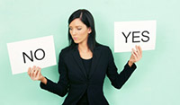 Woman holding yes and no signs, trying to decide her response