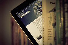Tablet sticking out from a stack to book to symbolize the continuous learning that leaders need to do