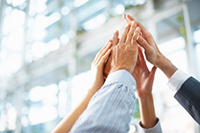 Four people's hands grouped together signifying teamwork